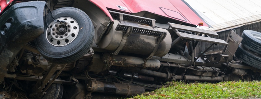 Truck overturned and lying in ditch on side