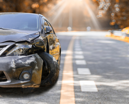 Artumn road. Front of black color car big damaged and broken by accident on road parking can not drive any more. With copy space for text or design