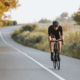 Professional cyclist in helmet riding bicycle on paved road