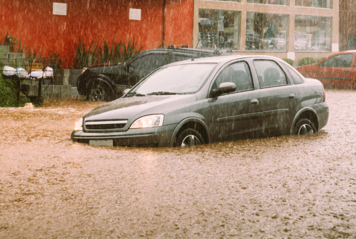 Unidentifiable passengers stuck in a car during heavy rains and flash flood - insurance claim concept
