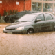Unidentifiable passengers stuck in a car during heavy rains and flash flood - insurance claim concept