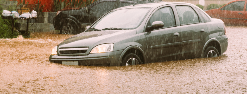 Unidentifiable passengers stuck in a car during heavy rains and flash flood - insurance claim concept