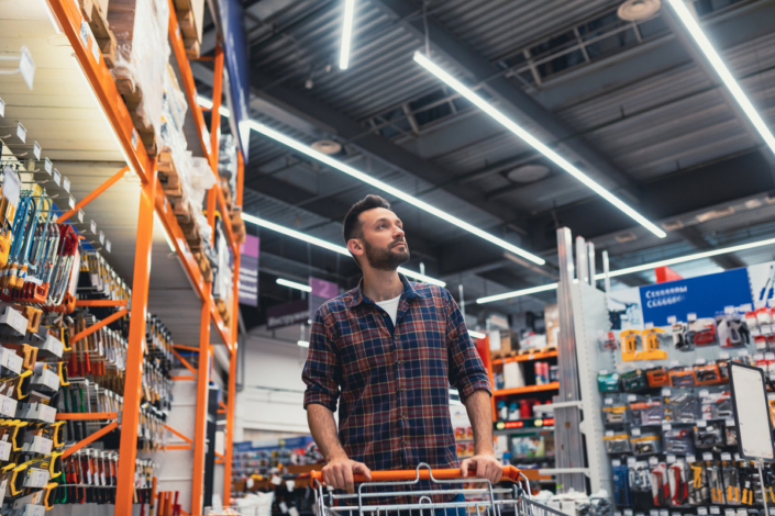 buy a man walking with a basket in a hardware store.
