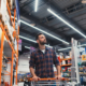 buy a man walking with a basket in a hardware store.