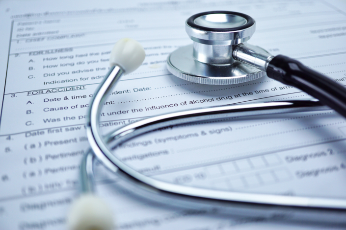 Health insurance accident claim form with stethoscope on desk