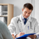 Doctor with clipboard talking to a patient during an exam