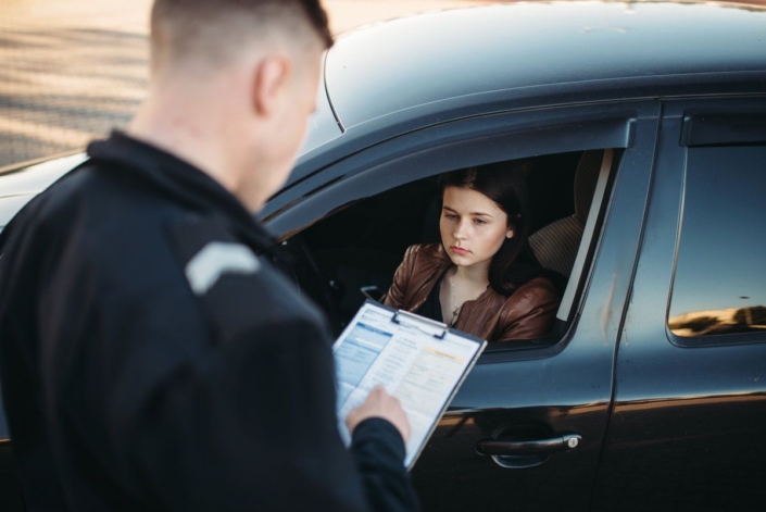 oliceman in uniform writes fine to female driver