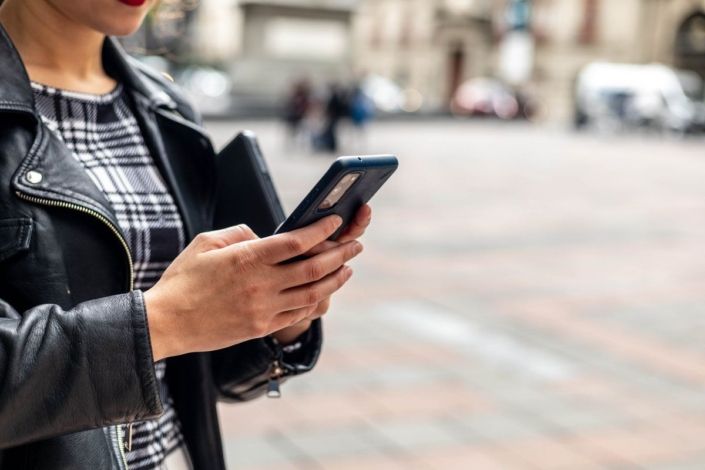 Close-up shot of a girl's hands typing on a mobile phone.